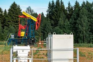 oil pumping station and pumpjack in a clearing in the forest photo