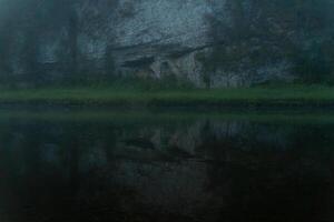 rock on the river bank in the morning twilight photo