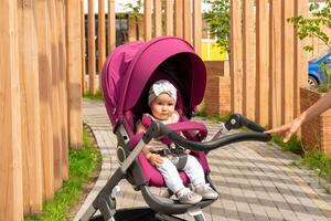 cute baby in a stroller for a walk with mom photo