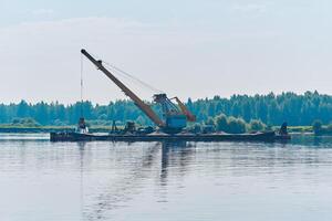 dredging boat is working to deepen the fairway on the river photo