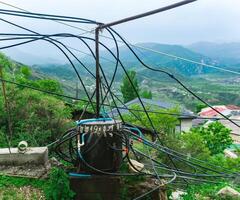 impromptu plumbing in a mountain village, water from a spring enters the tank through a pipe and is distributed to houses using hoses photo