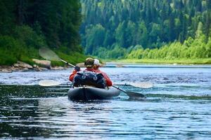 couple in a two-seater kayak rafting down the river among the mountains photo