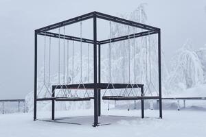 outdoor furniture - picnic table with swing benches - in a frosty winter park photo