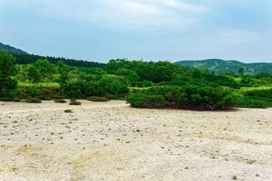 landscape of Kunashir island, tephra beach of a hot lake at the bottom of Golovnin volcano caldera photo