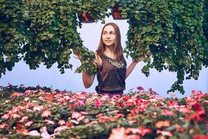 young woman in a dress among flowers on a light blue background photo