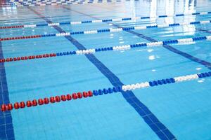 fragment of the competition pool with blue water and marked swimming lanes photo