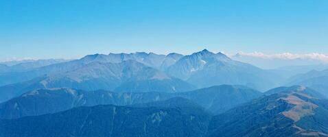 view of high mountains to the horizon from one of the peaks photo