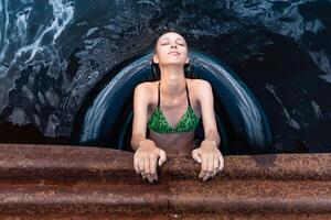 adolescente niña jugando en el agua utilizando un nadar tubo foto