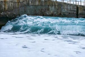 background - cold winter sea surf at a concrete pier photo