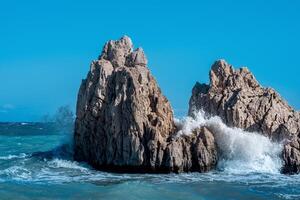 sea coastal cliffs among surf on a windy sunny day photo