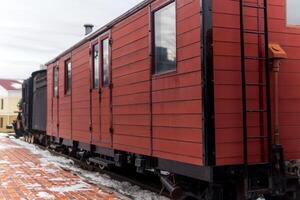 Clásico furgón con un vapor locomotora a el estación en invierno foto