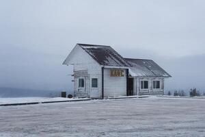 old wooden building of a transport cafe on a mountain pass in a snowy winter landscape in Perm Krai, Russia photo