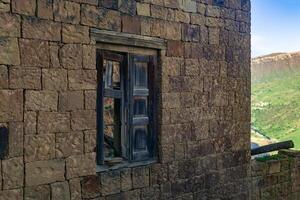 antiguo de madera ventana con persianas en el restos de el abandonado pueblo de gamsutl, daguestán foto