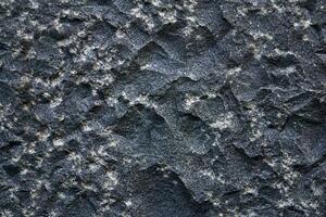 background, texture - the surface of a roughly hewn granite block photo