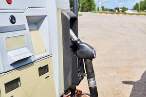 pistola de repostaje en la toma del dispensador de combustible foto