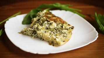 fried egg omelet with spring sorrel inside, on a wooden table. video