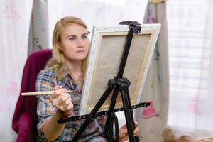 woman artist paints at an easel photo