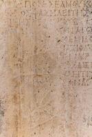 casi borrado antiguo griego inscripción en el Roca foto