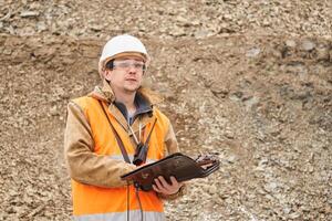 geólogo o minería ingeniero con bolso tableta para trabajando documentación a el minería sitio foto