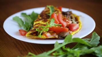 frito ovo omelete com selvagem cogumelos e tomates, em uma de madeira mesa video