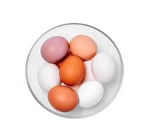huevos de diferente colores desde blanco a marrón en un vaso bol, aislado en un blanco antecedentes foto