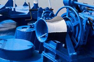 capstan and other mechanisms, painted blue, on the foredeck of the ship, close-up photo