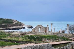 ruins of antique greek basilica with columns on the seashore in Chersonesos photo