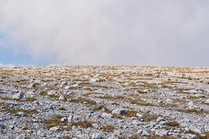 abandonado alpino meseta cubierto con blanco piedras foto