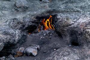 constantly burning fire at the place of a natural gas emission on Mount Chimaera Yanartas, Turkey photo