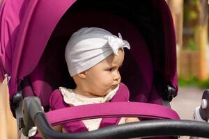 funny baby in a stroller is dissatisfied with something photo