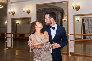 man and woman dancing tango in vintage hall with mirrors photo