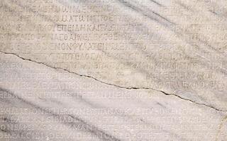 fragment of a marble slab with a carved text on the collection of taxes in ancient Greek from Chersonesos, Crimea photo