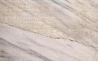 fragment of a marble slab with a carved text on the collection of taxes in ancient Greek from Chersonesos, Crimea photo