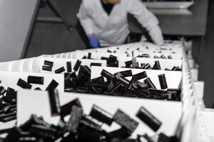 sliced fruit pastilles climb the conveyor belt to a packaging machine in a confectionery factory photo