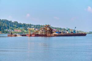 floating sand mining plant - dredger and separator - on the river photo