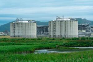 planta para el producción de licuado natural gas en un natural zona en contra el fondo de montañas foto