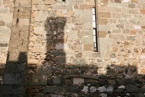 albañilería pared de un antiguo castillo, en cuales el sombra de el Chimenea de otro edificio es visible foto