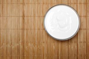 bowl with sour cream on the table, top view photo