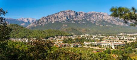 view and of the town in a mountain valley Kemer, Turkey with Mount Tahtali Lycian Olympus in the distance photo