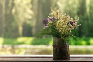 bouquet of wild plants in a rusty tin can photo