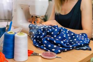 blurred hands of a dressmaker woman working on a sewing machine photo