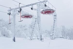 upper station of the ski lift on a snow-covered hilltop among frosty trees photo