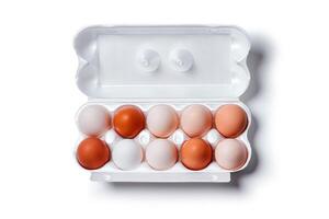 eggs of different colors from white to brown together in a crate, isolated on a white background photo