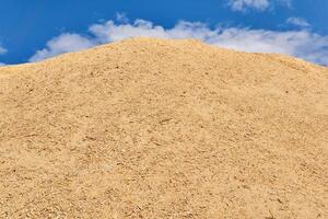 huge pile of wood sawdust against the sky photo