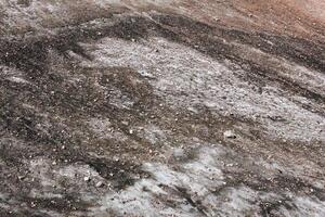 superficie de un derritiendo montaña glaciar cubierto con piedras y escombros foto