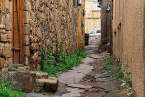 door in a narrow alley between houses in mahallas of Derbent in the historical center of the city photo