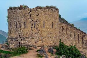 antiguo torre en parte superior de un escarpado acantilado en un montañoso área, gunib shamil fortaleza en daguestán foto