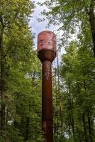 old metal water tower in the forest photo