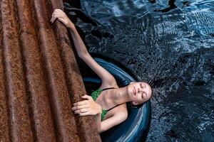 teen girl playing in the water using a swim tube photo