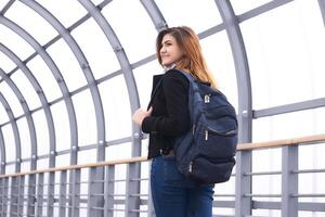 young beautiful woman looks back walking along the covered overpass photo